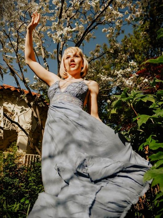 Jenni wearing a dress, near trees.